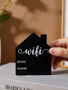 Detail of a minimalist black house-shaped WiFi password sign displayed on a grey book