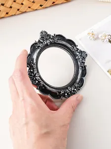 Close-up of a vintage black-silver resin picture frame with ornate embossed carvings