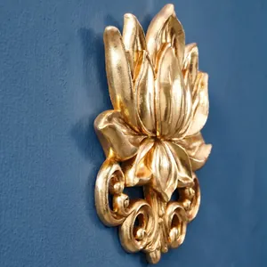 Detailopname van een gouden 3D lotus reliëf wandsculptuur met verfijnde metalen textuur.
