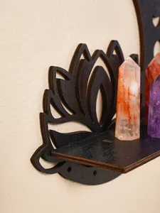 Macro detail of a black wooden lotus moon wall shelf displaying healing crystal points
