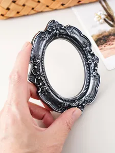 Detailed view of a vintage European black and silver embossed resin mini picture frame.