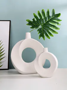 Detailansicht von zwei minimalistischen weißen Donut-Vasen aus Harz in moderner Umgebung