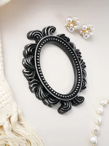 Detailed view of a vintage European style carved resin picture frame in black and silver
