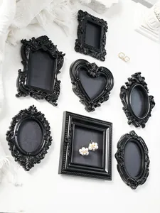 Set of seven vintage black mini magnetic frames with ornate baroque details for home decor.