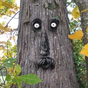 Outdoor resin tree face decoration with quirky old man features mounted on bark