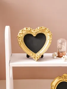 Detailed view of the ornate golden heart-shaped relief picture frame on a shelf