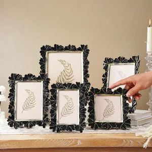 Macro view of vintage black and gold daisy pattern photo frames on wood table