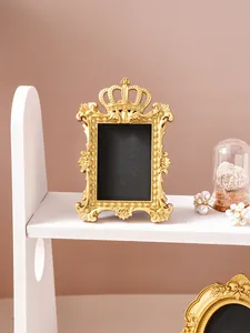 Detailed view of a vintage golden crown picture frame featuring ornate baroque relief carving