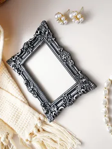 Detail of ornate relief carving on vintage black and silver resin picture frame