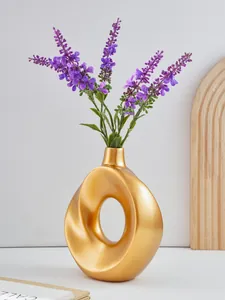 Goldene Donut-Vase aus Harz mit violettem Lavendel als Detail für die Tischdekoration.