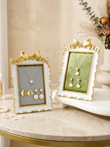 Close-up view of elegant French style gilded bow jewelry stands with velvet lining