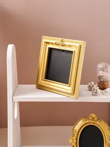 Detailed view of a vintage gold square picture frame featuring elegant floral relief carvings