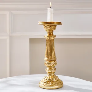 Primer plano detallado de un candelabro tallado en oro con una vela blanca encendida arriba