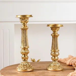 Vista detallata de dos candelabros europeos tallados en oro sobre una mesa de madera