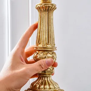 Primer plano detallado de un candelabro tallado dorado de lujo con detalles clásicos