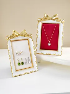 Detail of French gilded bow jewelry display stands with red and cream velvet linings