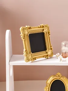 Vintage gold ornate frame with detailed floral relief shown on a white display shelf