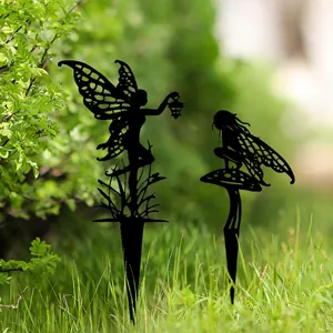 Detail van zwarte fee silhouet tuinstokken geplaatst in weelderig groen gras