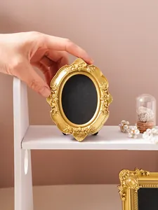 Detailed macro view of a vintage gold ornate oval photo frame for elegant desktop decoration