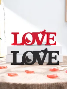 Close-up detail of romantic wooden LOVE letter decoration with butterfly design for weddings.