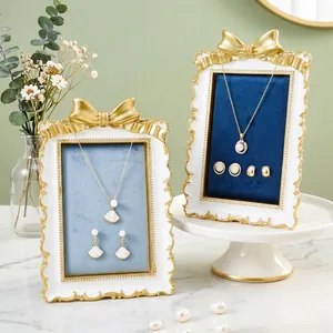 Elegant French gilded bow jewelry display stand with velvet lining for earrings and necklaces.