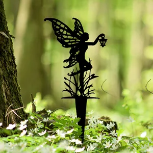 Zwarte fee tuinornament silhouet met lantaarn in een mooie natuurlijke bosomgeving