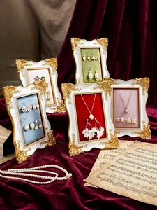 Marcos de exhibición de joyas de estilo europeo con forro de terciopelo y dorado.