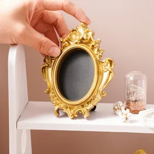 Vintage gold baroque photo frame with elegant relief carvings for desktop display decor.