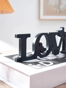 Black wooden LOVE letter table decoration with butterfly design for romantic wedding party decor.