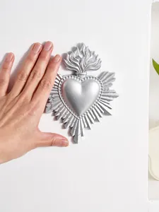 Zilveren hars heilig hart muurdecoratie getoond met hand voor schaalvergelijking