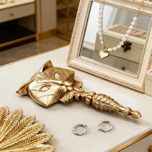 Detailed macro view of vintage gold resin fox hand mirror with intricate carved patterns