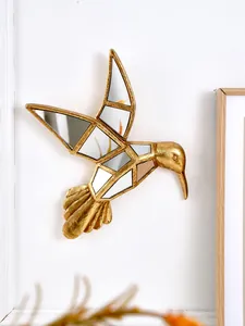 Détail d'un colibri décoratif en résine dorée avec incrustations de miroirs géométriques