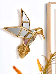 Détail rapproché d'un colibri décoratif en résine dorée avec miroirs géométriques incrustés