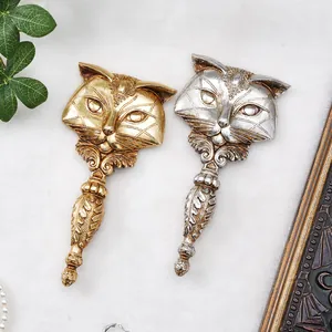 Close-up of vintage fox-shaped hand mirrors in gold and silver resin finishes