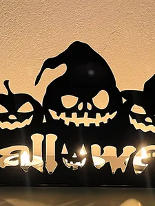 Detail view of black iron hollow Halloween candle holder with pumpkin and monster designs