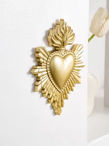 Gedetailleerde opname van gouden hars heilig hart wanddecoratie met vlammenstralen