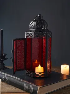 Vintage Marokkaanse ijzeren lantaarn met rood reliëfglas en warm LED-kaarslichtdetail
