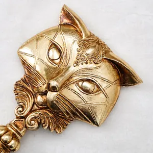 Close-up detail of ornate fox-shaped carving on vintage gold resin handheld mirror