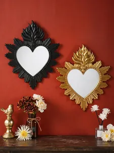 Specchi da parete gotici a cuore sacro con design a fiamma su parete rossa accesa.