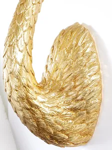 Vista macro dettagliata della decorazione murale a cigno dorato con trama piumata in resina