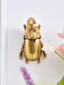 Primer plano de un escarabajo rinoceronte decorativo de resina dorada para pared creativa
