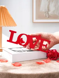 Close-up detail view of red wooden LOVE letter decoration with butterfly cutout for romantic events.