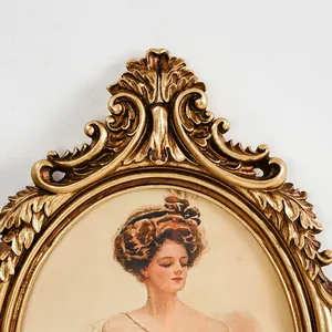 Close-up of ornate gold French vintage oval photo frame with detailed floral carvings.