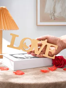 Gold wooden LOVE letter decor with butterfly cutout for romantic wedding party table centerpiece.