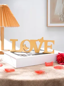 Gold love letter table decor with delicate butterfly detail for romantic wedding party settings.