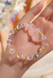 Detalle de una pulsera de cristal facetado con cuentas coloridas sobre una mano