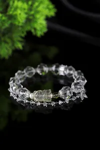 Detalle de las cuentas de cristal facetado y el colgante de oso de cuarzo limón tallado.