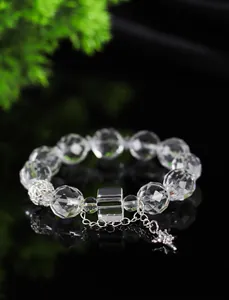 Primer plano detallado de una pulsera de cristal facetado con adornos en plata