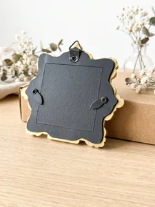 Vista dettagliata del retro di una mini cornice dorata vintage con gancio e chiusure