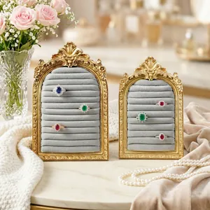 Detail of vintage golden arched jewelry display stands with velvet slots for rings.